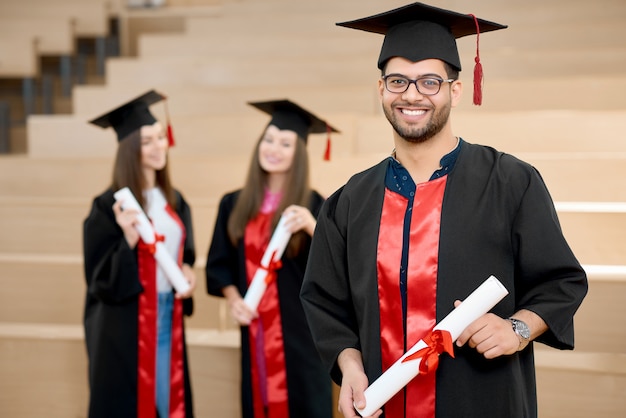 Happy smiling boy keeping university diploma.