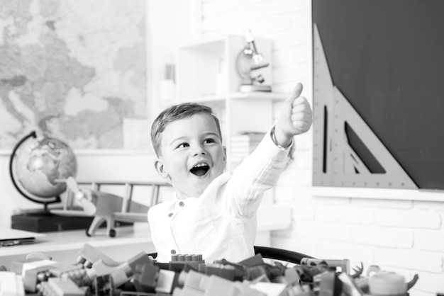 Happy smiling boy with thumb up is going to school for the first time