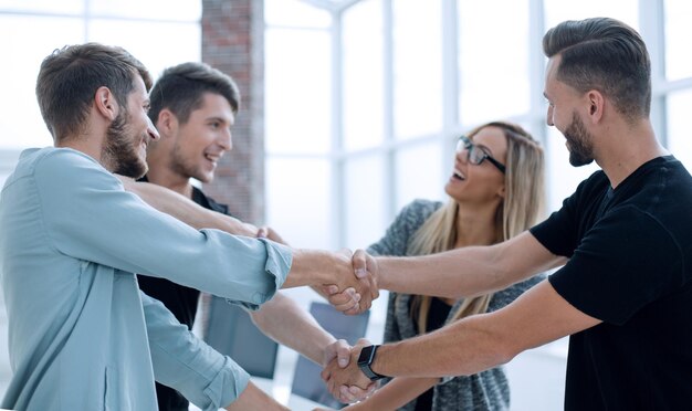 Foto squadra sorridente felice di affari che sta in fila all'ufficio