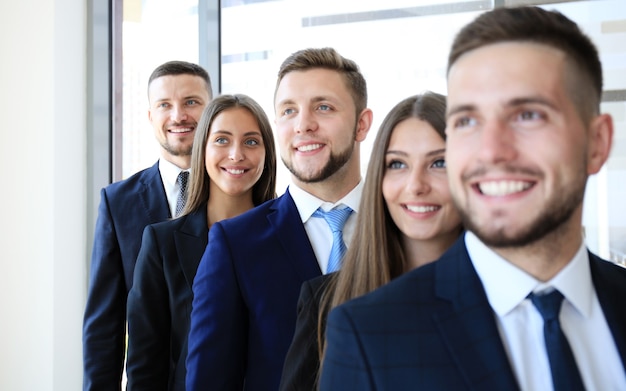 Photo happy smiling business team standing in a row at office
