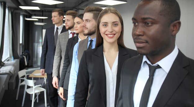 Photo happy smiling business team standing in a row at office.