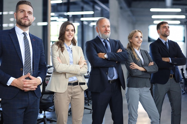 Happy smiling business team standing in a row at office