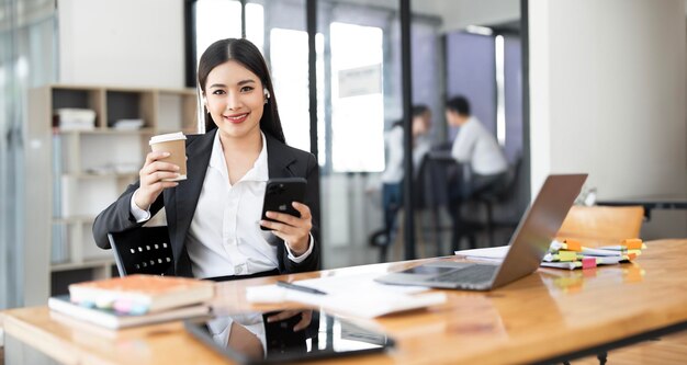 Happy smiling business woman working on laptop at office Businesswoman sitting at her working place