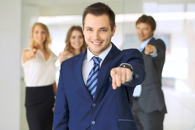 Happy smiling businessman and his colleagues pointing by finger into the camera Concept of employer and success team