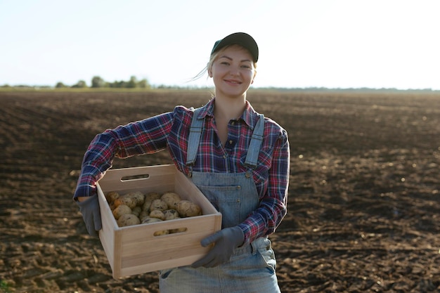 행복한 미소를 짓고 있는 백인 여성 감자 농부나 정원사 농업 식품 생산 수확 개념