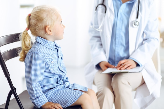 Happy smiling child patient at usual medical inspection. doctor\
and patient in clinic. medicine, healthcare concepts.