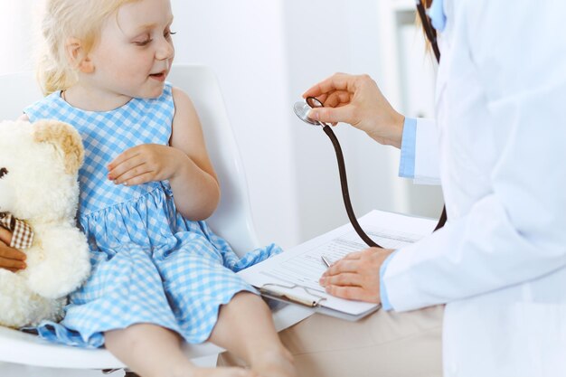 Happy smiling child patient at usual medical inspection. doctor\
and patient in clinic. medicine, healthcare concepts.