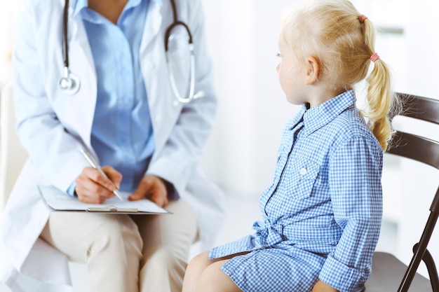 Happy smiling child patient at usual medical inspection. doctor\
and patient in clinic. medicine, healthcare concepts.