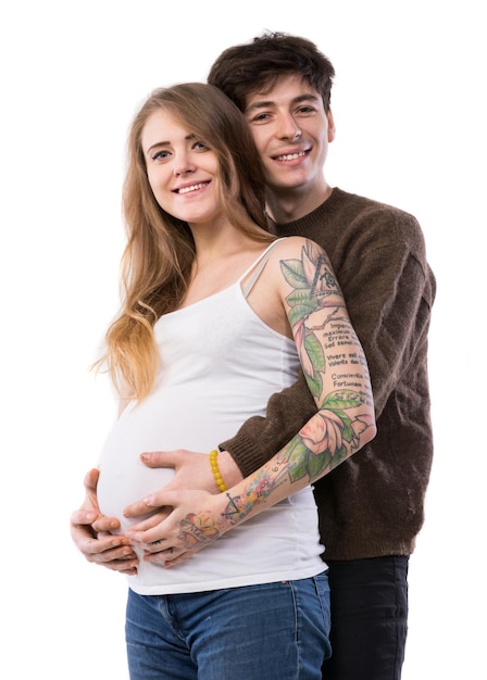 Happy smiling couple in love expecting child posing in studio on a white background