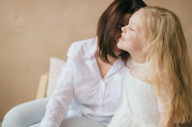 Happy smiling daughter with her mom indoor