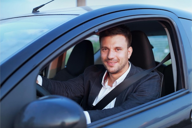 Photo happy smiling driver in the car portrait of young successful business man