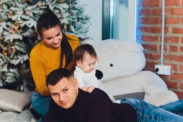 Happy smiling family near the Christmas tree.