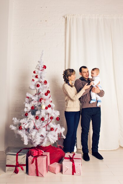 Foto famiglia sorridente felice vicino all'albero di natale