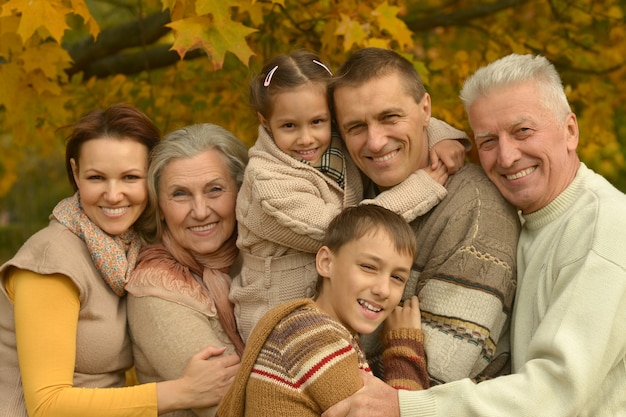 Счастливая улыбающаяся семья, расслабляющаяся в осеннем лесу