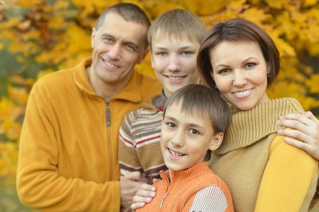 Happy smiling family relaxing in autumn forest