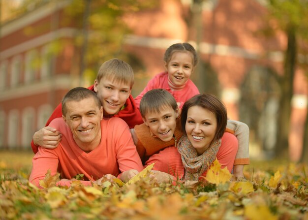 Happy smiling family relaxing in autumn forest