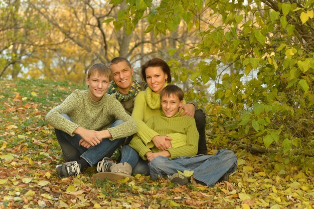 Happy smiling family relaxing in autumn forest