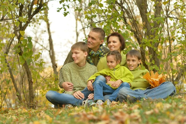 Happy smiling family relaxing in autumn forest