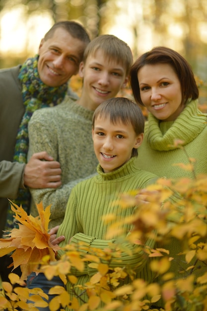 Happy smiling family relaxing in autumn forest