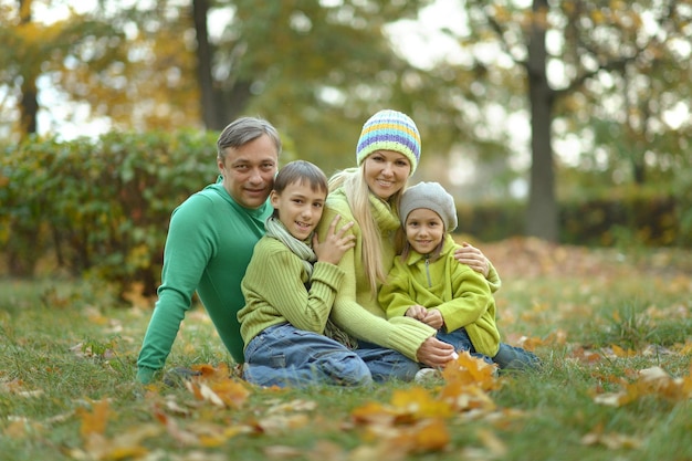 Famiglia sorridente felice che si rilassa nella foresta di autunno