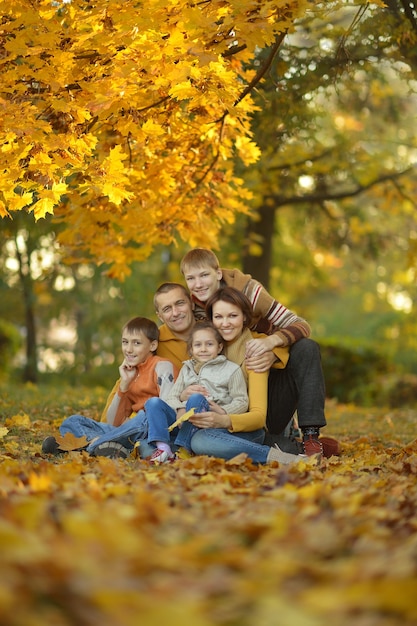 Happy smiling family relaxing in autumn forest