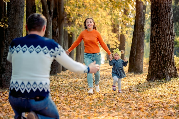 Happy smiling family relaxing in autumn park