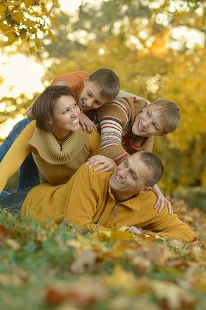 Фото Счастливая улыбающаяся семья, расслабляющаяся в осеннем лесу