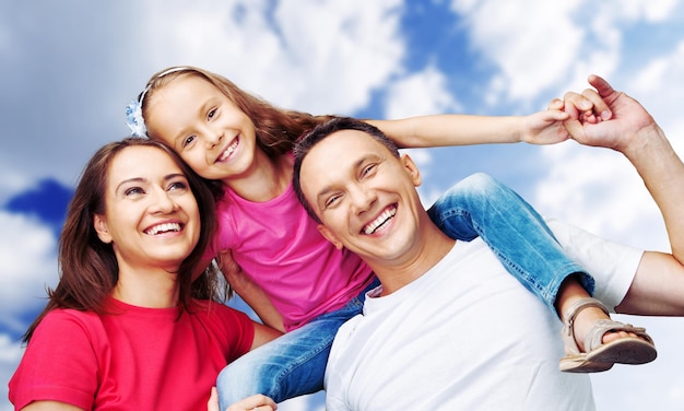 Happy smiling family with daughter on autumn trees background