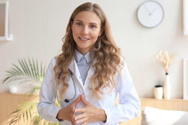 Photo happy smiling female doctor in white uniform coat and stethoscope.