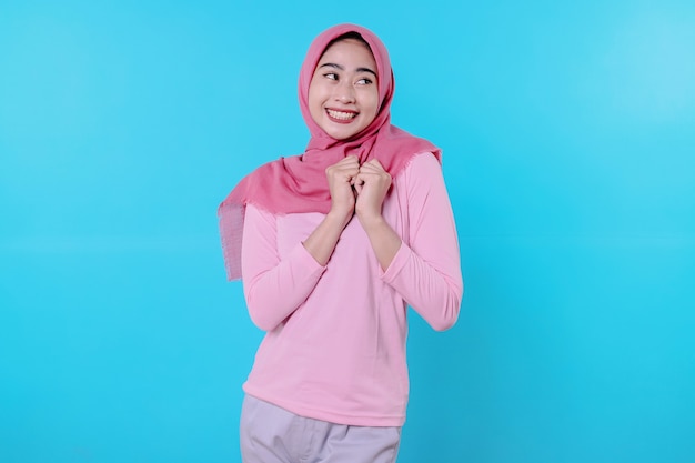 Happy smiling female with attractive appearance and wearing hijab, pink t shirt showing smile good mood