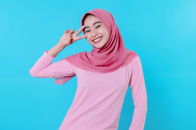 Happy smiling female with attractive appearance and wearing hijab, pink t shirt showing smile good mood