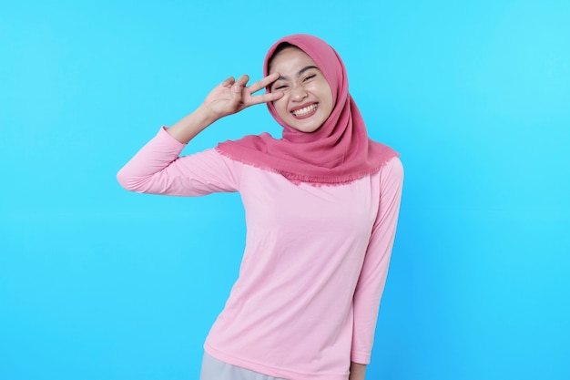 Happy smiling female with attractive appearance and wearing hijab, pink t shirt showing smile good mood