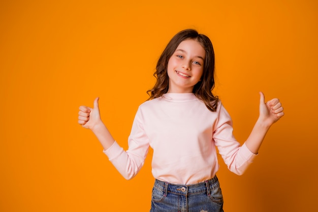 Ragazza felice e sorridente con i pollici in su