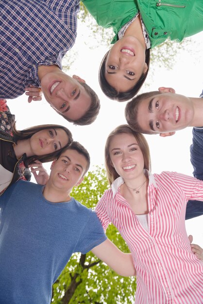 Un gruppo di giovani amici sorridenti e felici che stanno insieme all'aperto nel parco