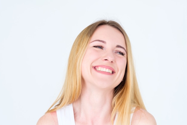 happy smiling joyful blonde woman on white wall.