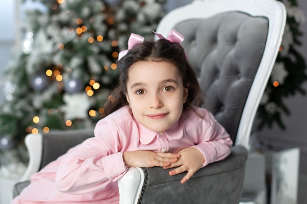 Happy smiling little girl near christmas tree