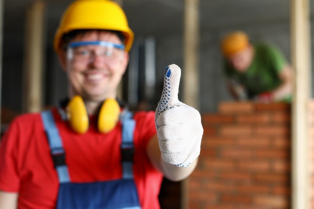 Happy smiling male worker showing thumb up gesture close-up. Fine house renovation or best contractors service concept