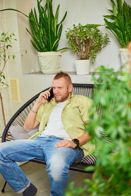 Happy smiling man holding mobile phone speaking talking