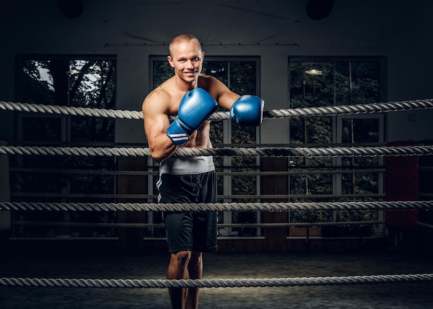 Happy smiling man is standing on the ring after kickboxing sparring.