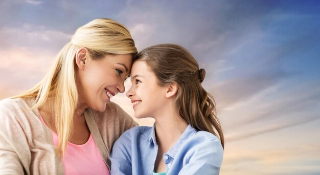 Foto madre e figlia sorridenti e felici sul cielo