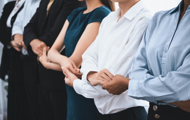 Happy and smiling multiracial office worker hold hand in a line promoting synergy and collaboration for business success Diverse professional office worker bond at modern workplace Concord