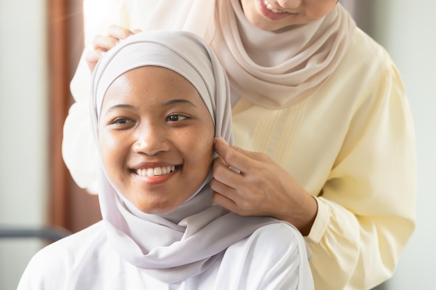 Premium Photo | Happy smiling muslim woman help dressing up her friend  concept of islamic sisterhood friendship among muslim people