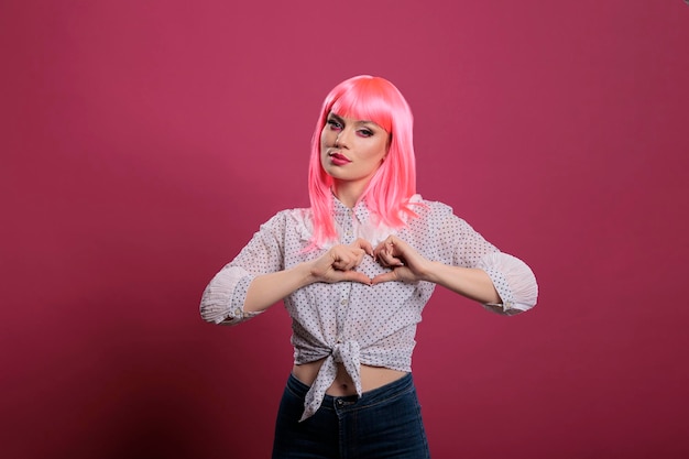 Happy smiling person doing heart shaped symbol with hands, advertising love and romance on valentines day. Expressing romantic gesture and sign of feelings, healthy happy relationship.