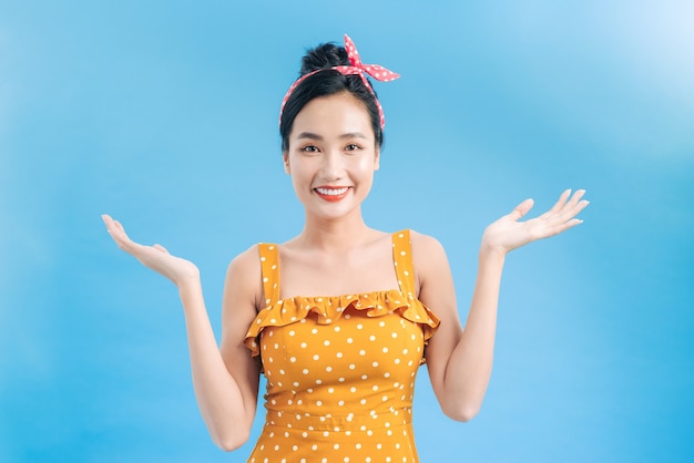 Happy smiling pretty pin up girl wearing hairband bow with empty hands