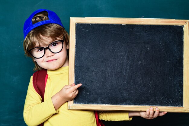 Alunni sorridenti felici che disegnano alla scrivania. allegro bambino sorridente alla lavagna. aula