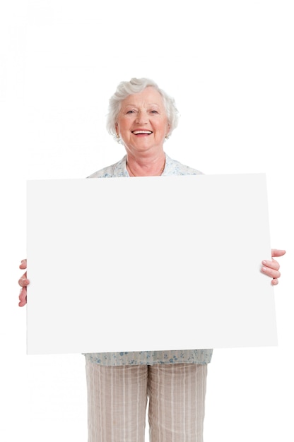 Happy smiling senior woman holding blank placard to write it on your own text, isolated on white 