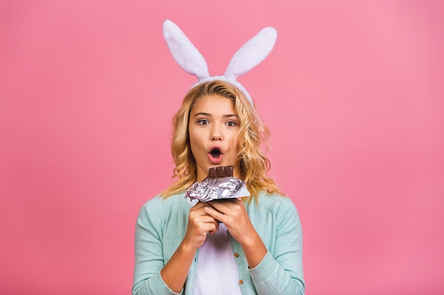 Happy smiling teen or kid girl biting tasty chocolate with empty copy space