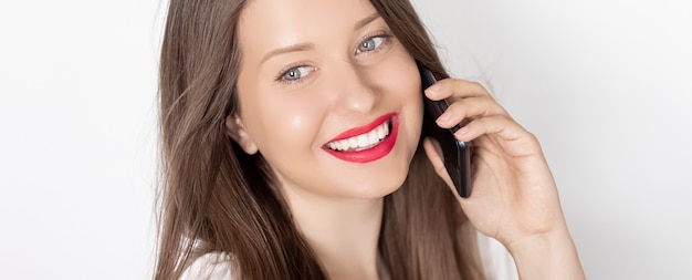 Счастливая улыбающаяся женщина, звонящая на портрет смартфона на белом фоне, люди, технологии и концепция коммуникации