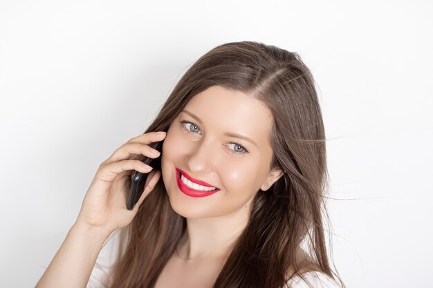 Happy smiling woman calling on smartphone portrait on white surface people technology and communication concept