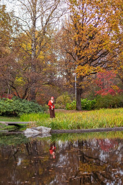 Happy smiling woman holding in her hands yellow maple leaves